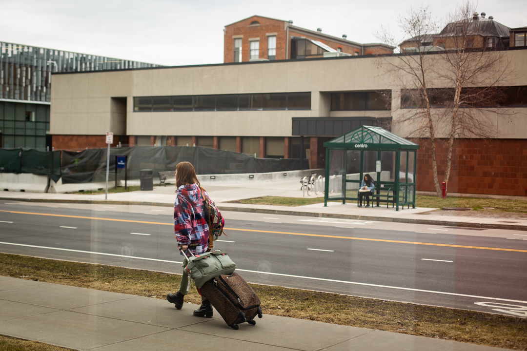 student pulling suitcase