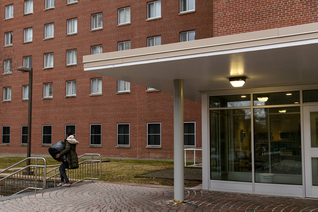 Student carrying bedding out of dorm